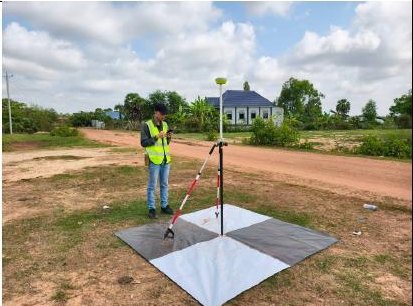 Field crew setting a GNSS antenna over a ground control target